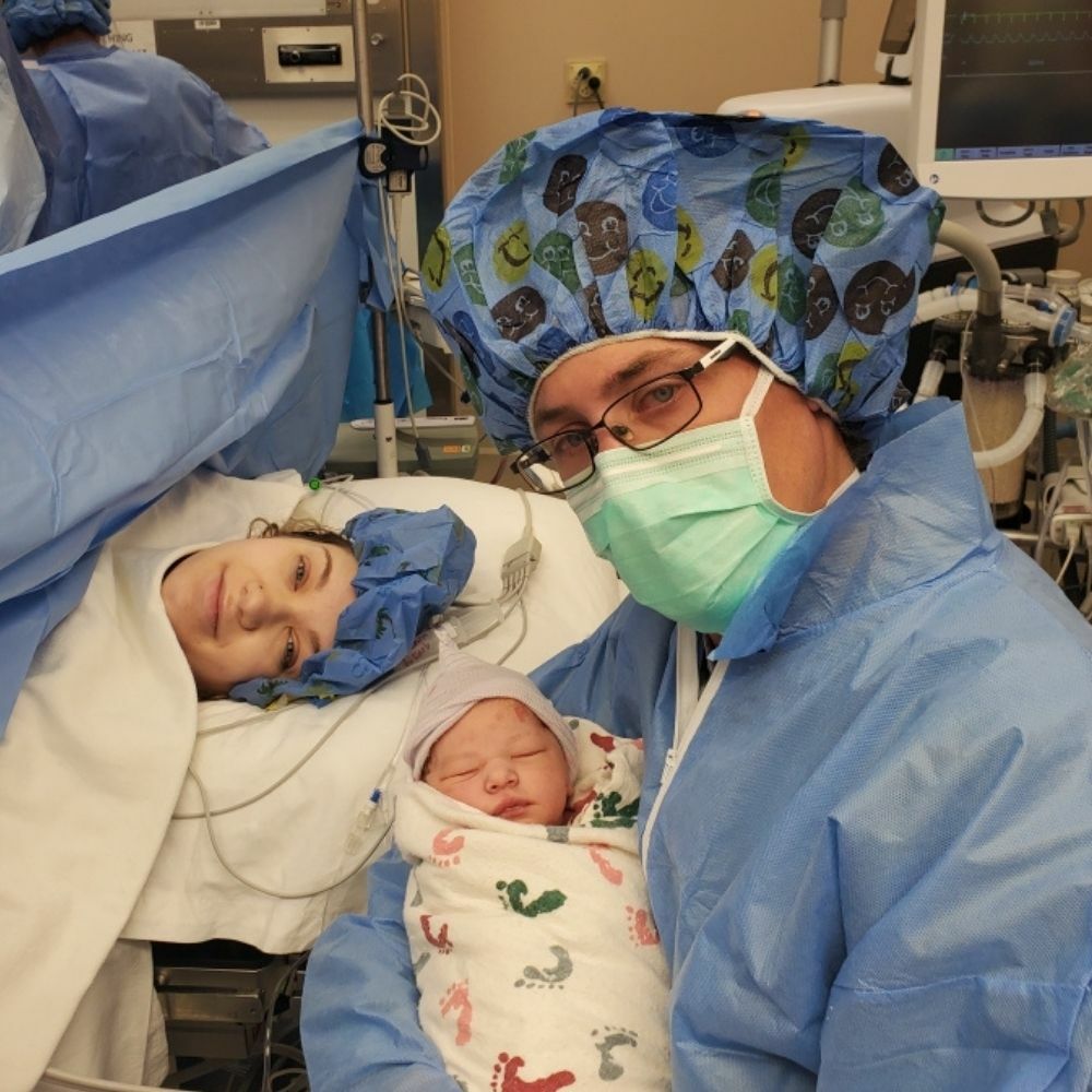 couple holding baby in hospital after cesarean